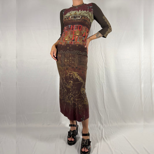 Person wearing a long, patterned dress on a plain background