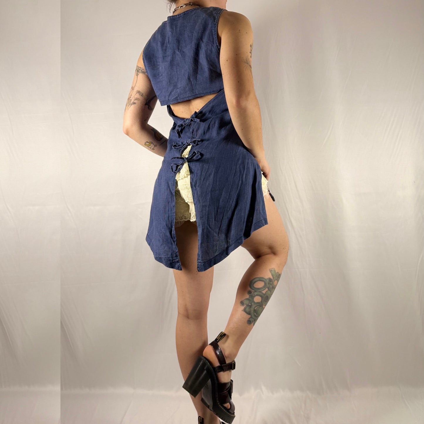 Back view of vintage French linen tunic featuring dramatic open back with three adjustable tie closures and long side slits.