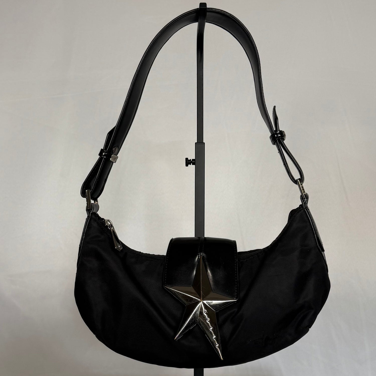 Y2K vintage Thierry Mugler black nylon baguette bag with patent leather trim and oversized silver star hardware, shoulder strap detail