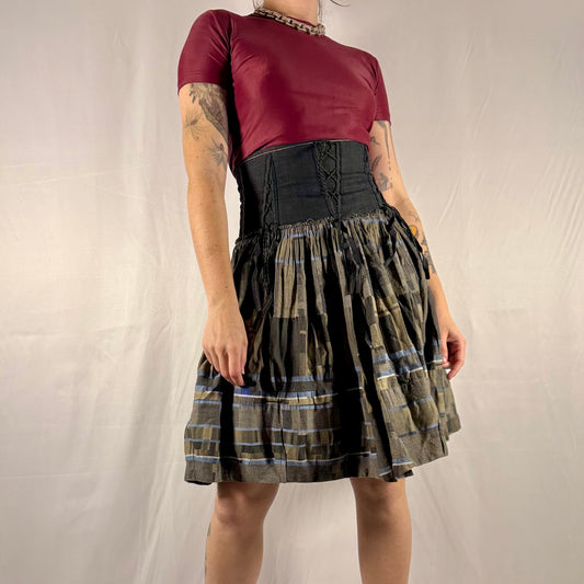 Vintage Y2K Marithé + François Girbaud reversible midi skirt made in Italy featuring a structured black corset waist with lace-up details and a gathered olive plaid cotton skirt.