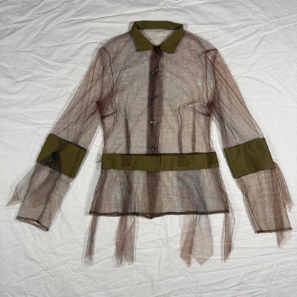 A sheer brown organza tulle blouse with olive green trim on the collar, cuffs, and waist, laid flat on a wrinkled white fabric background.