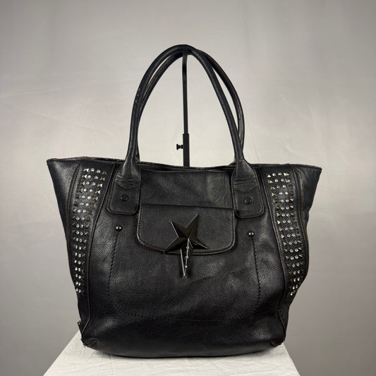 Vintage black Thierry Mugler tote bag with a sculptural star-shaped magnetic front pocket closure, studded side panels, textured exterior, leather detailing, and double shoulder handles.