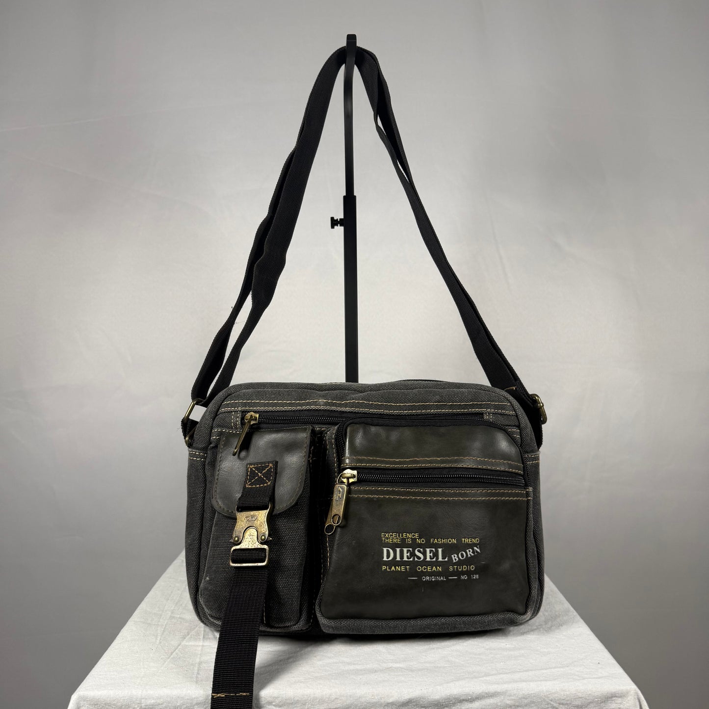 Vintage Y2K Diesel black canvas messenger bag with leather trim, utility pockets, adjustable shoulder strap, and brass hardware.