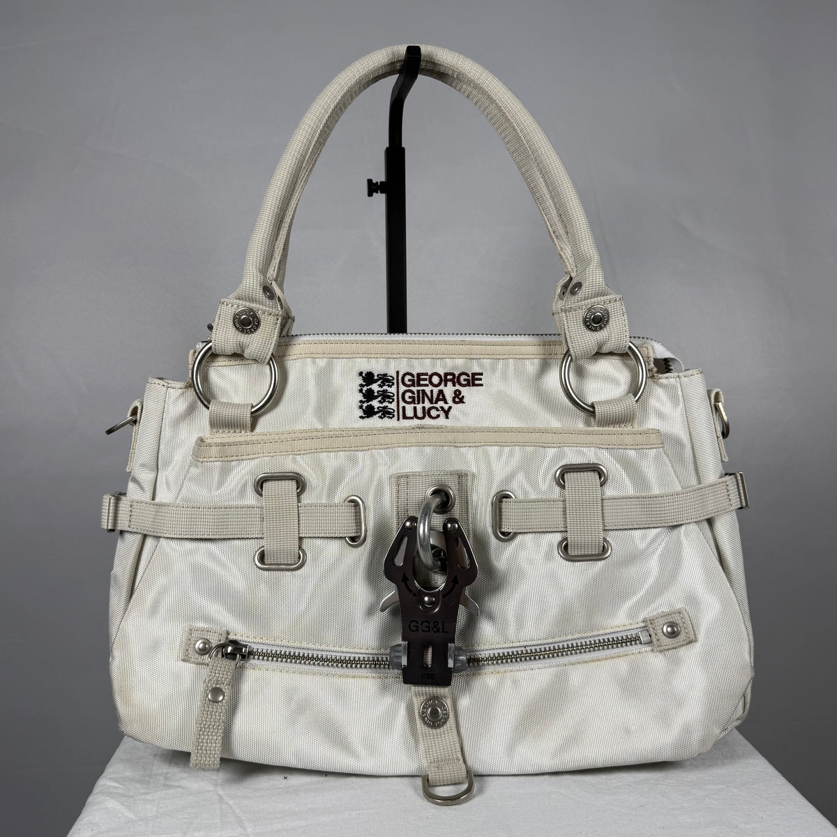Vintage 2008 George Gina & Lucy Jelly Bean white shoulder bag with oversized metal hardware, multiple zip pockets, embroidered branding and adjustable strap details.