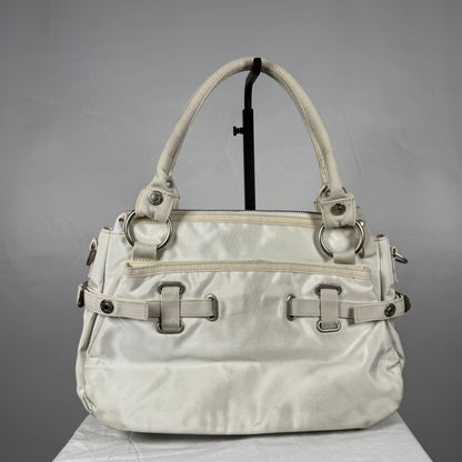 A light beige nylon handbag with silver-tone hardware, displayed on a black stand against a gray background.